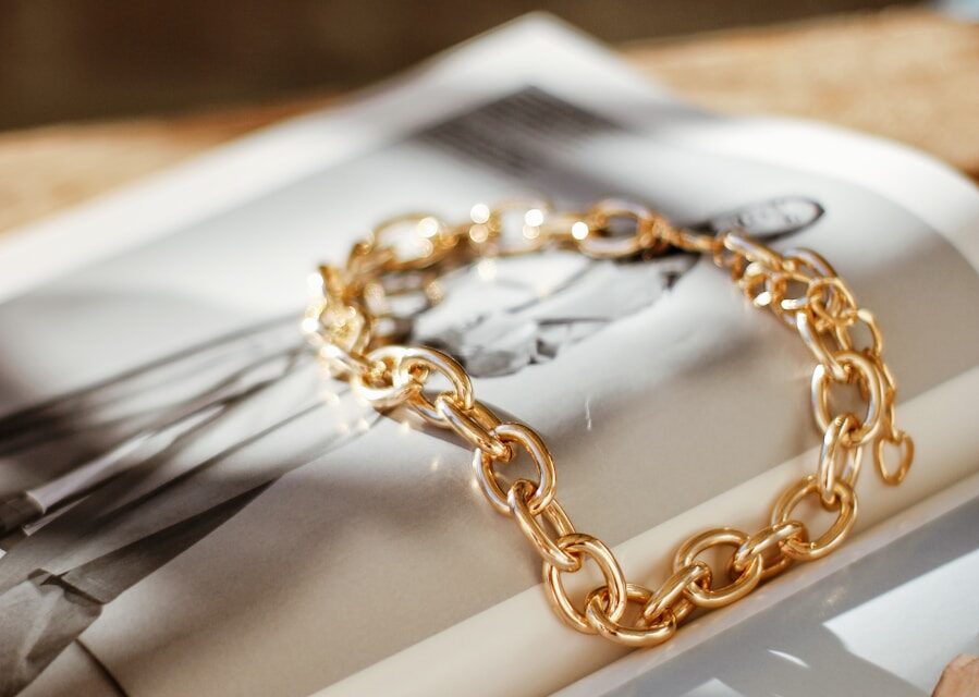 a gold chain bracelet sitting on top of a magazine